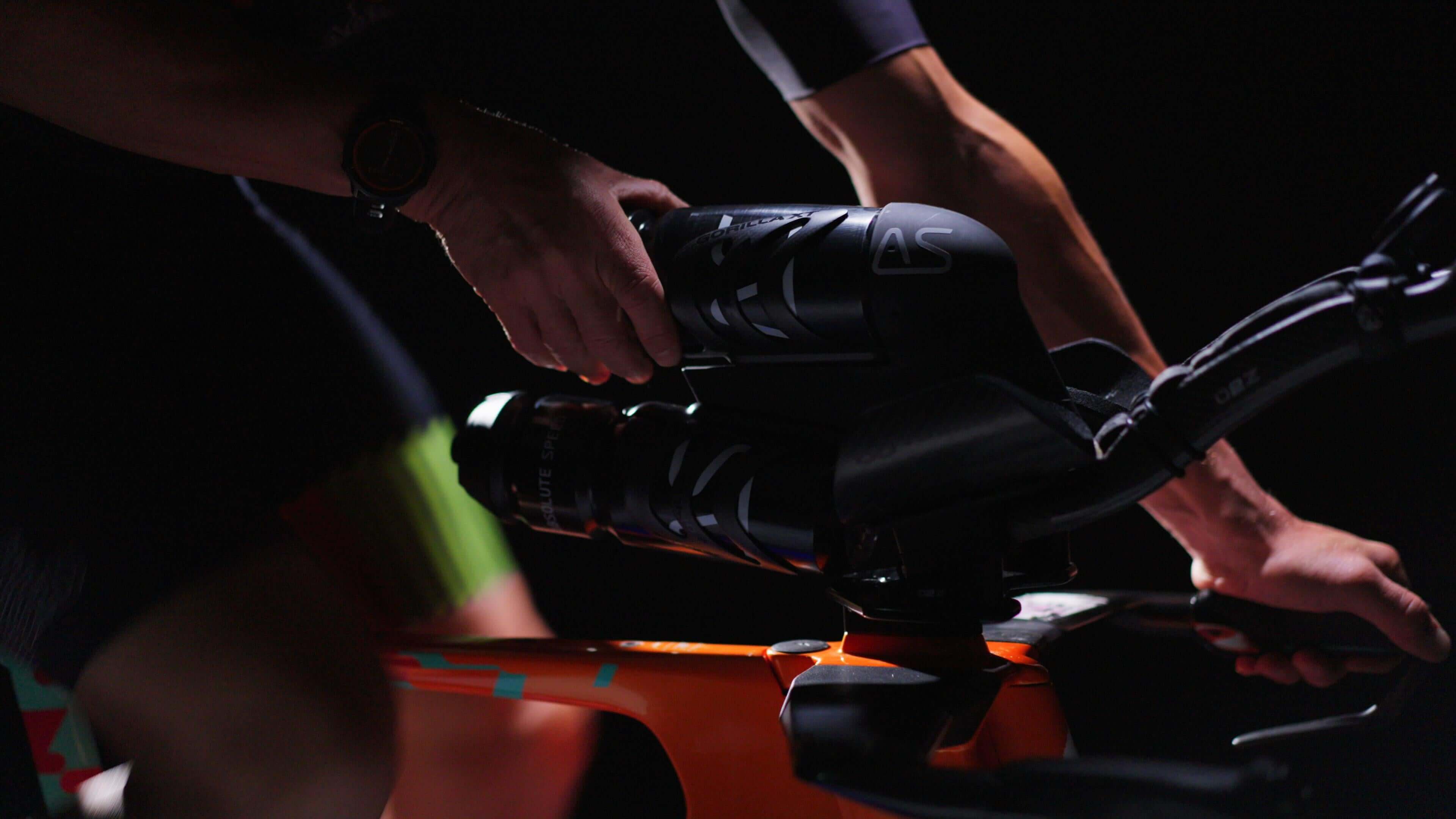 Person holding the AS Double Bundle bike specific mounting plate for hydration system on a bike handlebar.